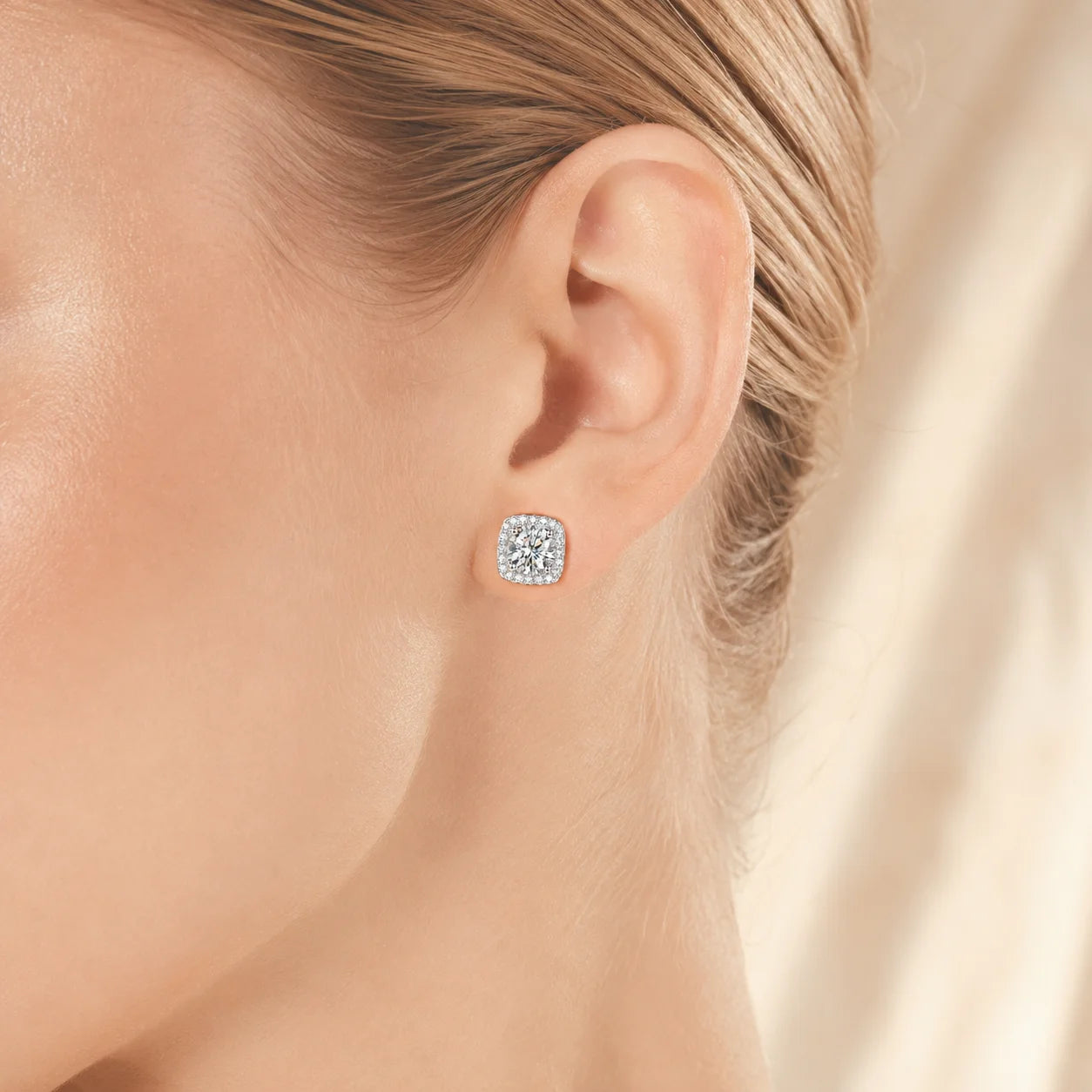 Cushion-halo moissanite stud worn on a model's ear