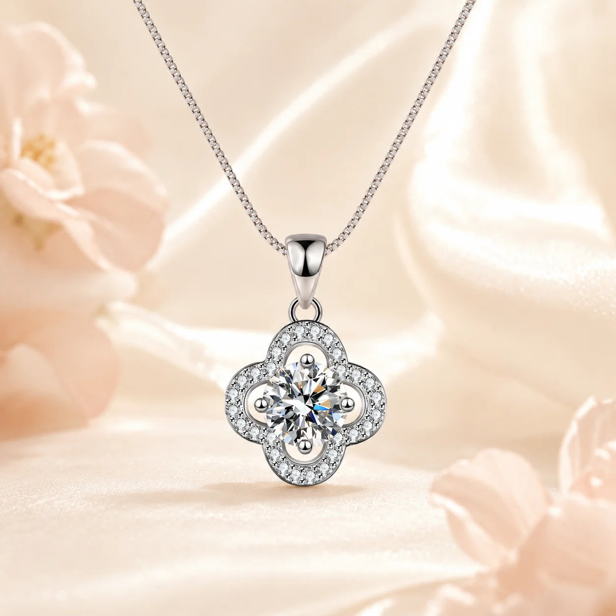 Four-petal pave moissanite pendant hanging above pale silk
