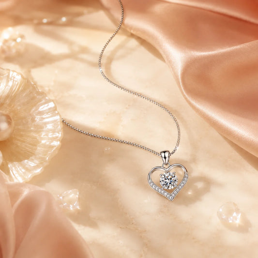 Eros' Coeur heart necklace resting beside blush silk