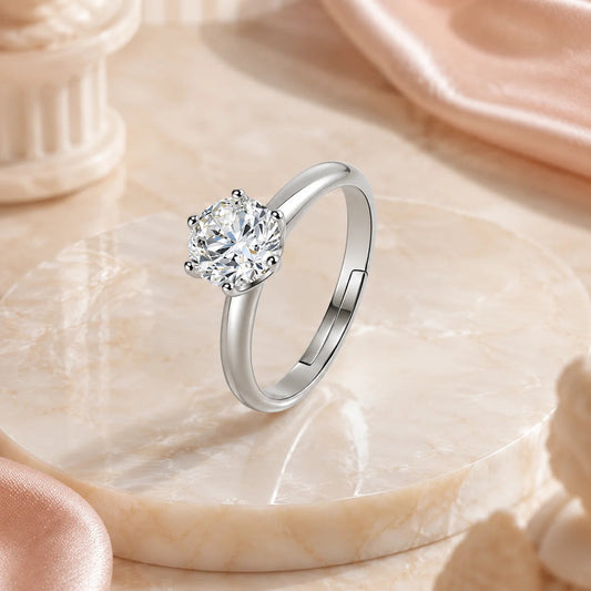 SENTO Eros Soleil six-prong solitaire moissanite ring on marble platform blush silk background