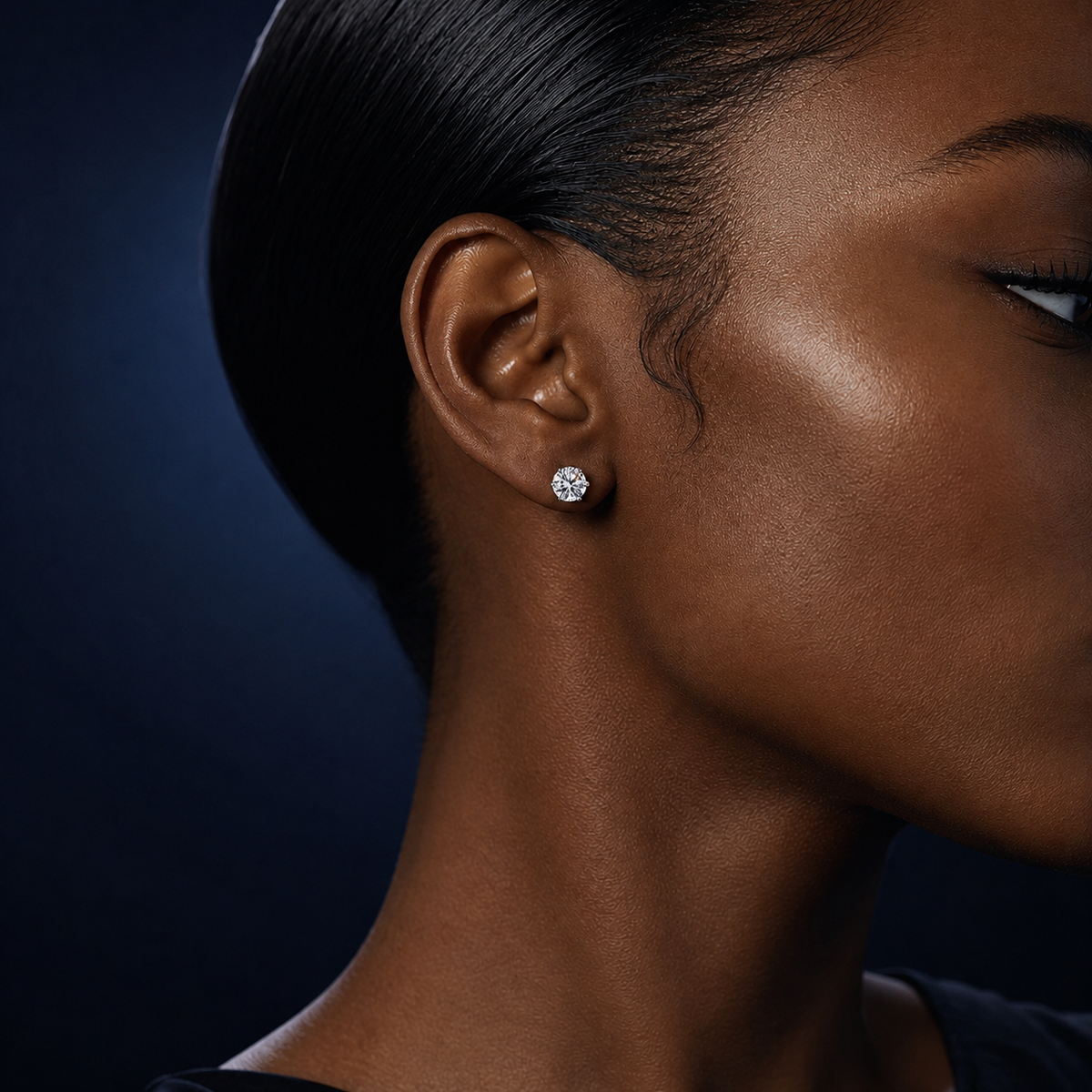 Aster six-prong round moissanite stud earring worn on a model's ear