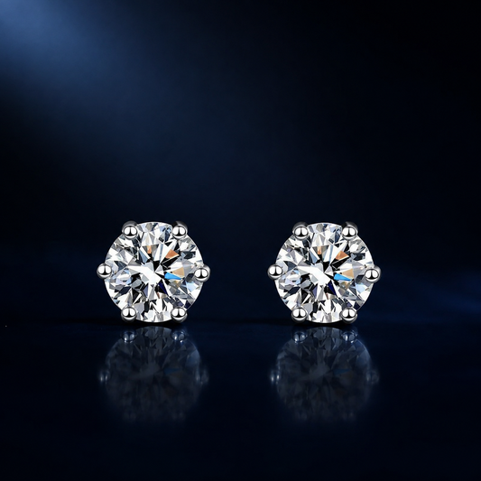Pair of Aster six-prong round moissanite stud earrings on a dark reflective surface