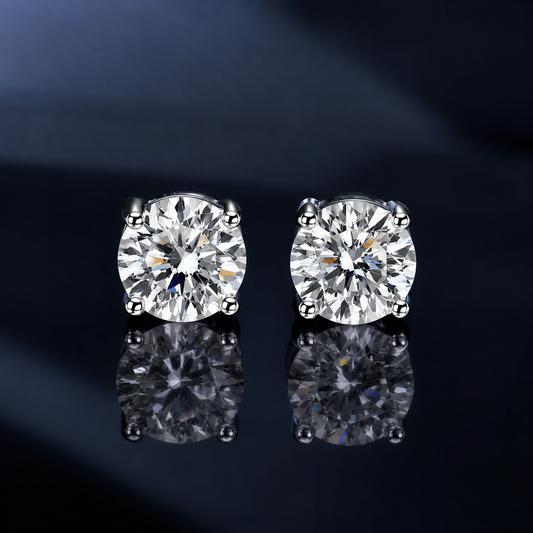 Pair of Lucent four-prong round moissanite stud earrings on a dark reflective surface