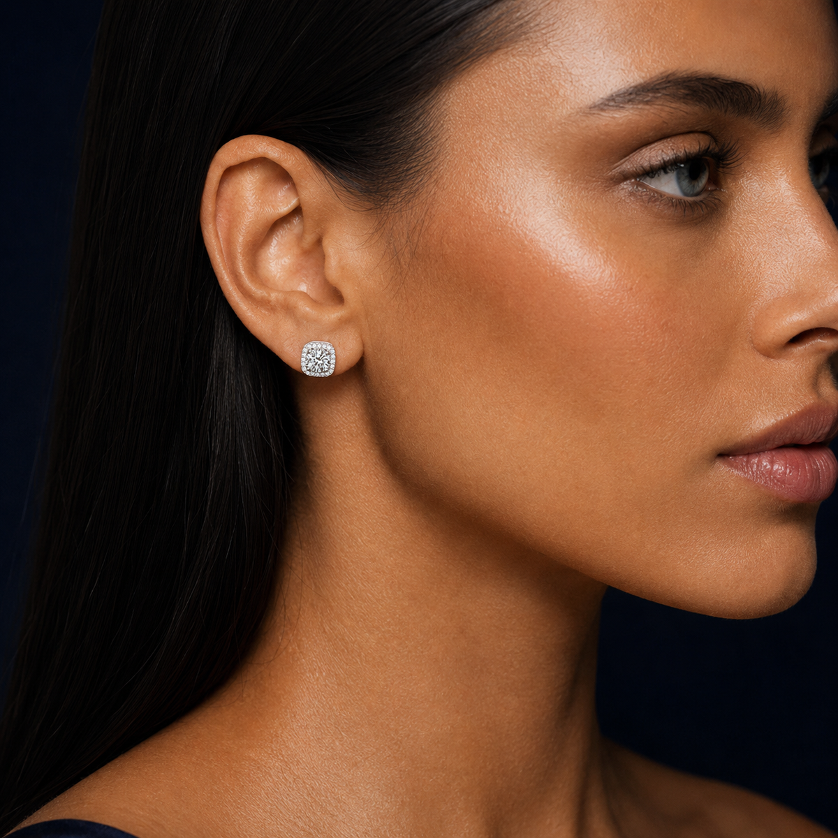 Orbit cushion-halo moissanite stud earring worn on a model's ear